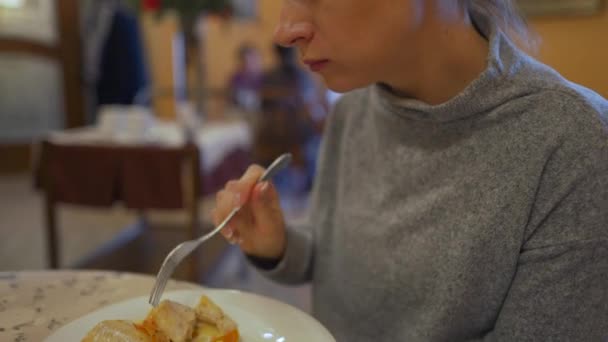 Woman is having lunch in a cafe. She eats fish and mashed potatoes — Stock Video