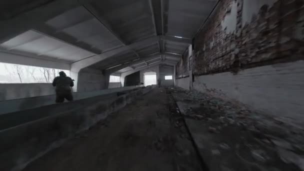 Group of people in masks and military uniforms are engaged in airsoft in an abandoned building. FPV drone shooting — Stock Video