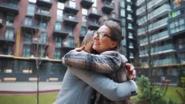 Duas mulheres felizes abraçam-se quando se encontram depois da separação longa. Movimento lento — Vídeo de Stock