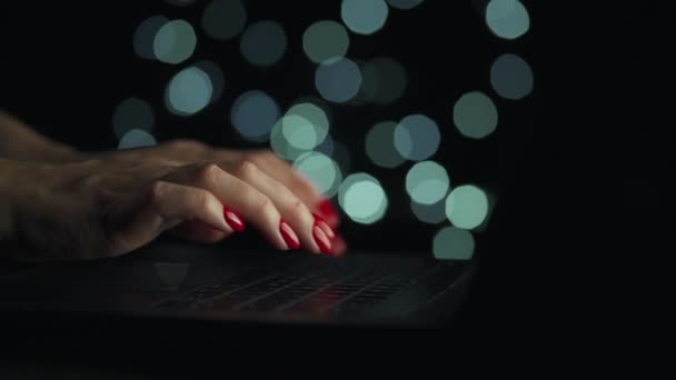 Kvindelige hænder skriver på en bærbar om natten. Sløret lys på baggrunden – Stock-video