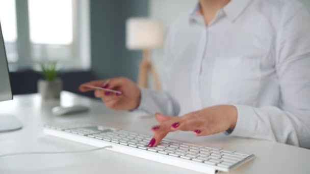 Kvinnan skriver kreditkortsnummer på datorns tangentbord. Hon handlar på nätet. Betalningstjänst online. — Stockvideo