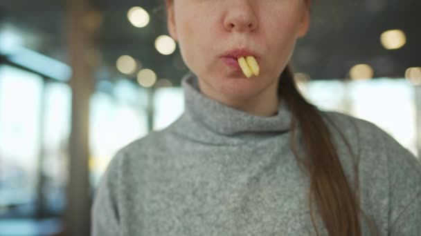 Mujer comiendo papas fritas en un café de cerca. — Vídeo de stock