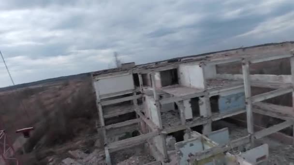 Drone FPV voa rapidamente e manobrável entre edifícios industriais abandonados e em torno de uma escavadeira. — Vídeo de Stock