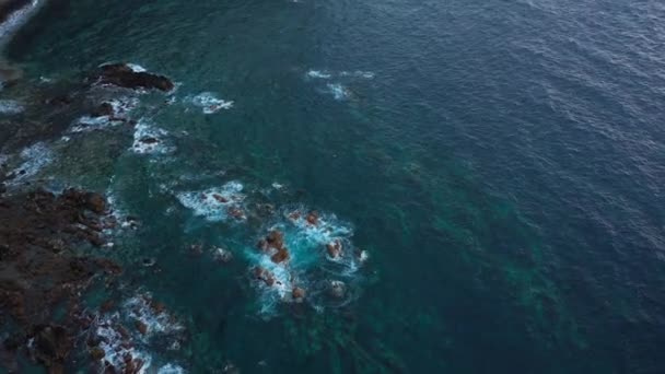 Egy elhagyatott part első látásra. Tenerife szigetének sziklás partja. Légi felvételek a partot elérő tengeri hullámokról — Stock videók