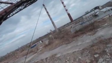 FPV insansız hava aracı terk edilmiş kazıcıların yakınında manevra yapabiliyor.