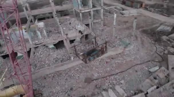 FPV κηφήνας πετά γρήγορα και ευέλικτο μεταξύ εγκαταλελειμμένων βιομηχανικών κτιρίων και γύρω από έναν εκσκαφέα. — Αρχείο Βίντεο