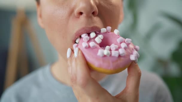 Mujer comiendo rosquilla dulce con malvaviscos. Primer plano — Vídeos de Stock