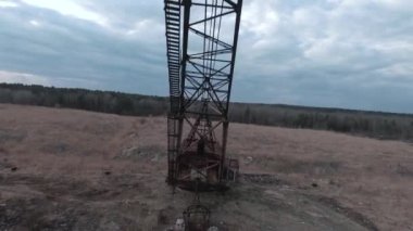 FPV insansız hava aracı, terk edilmiş paslı kazıcı yakınlarında manevra yapabilir.