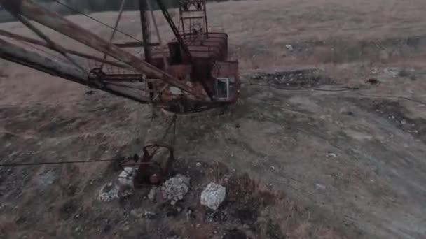 Drone FPV lata manewrowe w pobliżu zardzewiałej opuszczonej koparki spacerowej — Wideo stockowe