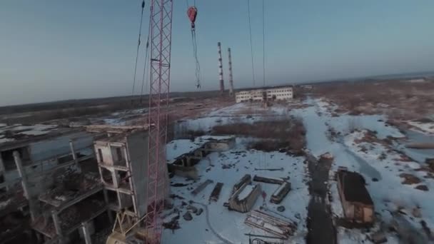 FPV-drönaren flyger snabbt och lättmanövrerad bland övergivna industribyggnader och runt en grävmaskin. — Stockvideo