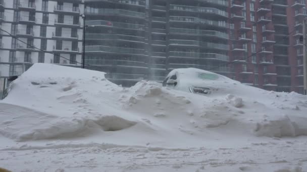 雪の吹雪の後に雪に覆われた車。バックグラウンドでの住宅建築. — ストック動画