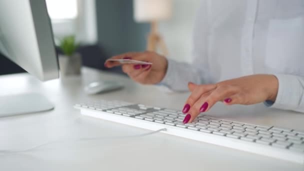 Mujer escribiendo el número de tarjeta de crédito en el teclado de la computadora. Está haciendo compras en línea. Servicio de pago en línea. — Vídeo de stock