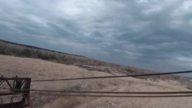FPV insansız hava aracı, terk edilmiş paslı kazıcı yakınlarında manevra yapabilir.