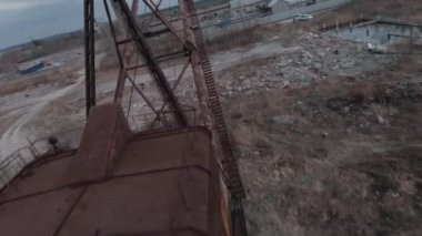 FPV insansız hava aracı, terk edilmiş paslı kazıcı yakınlarında manevra yapabilir.