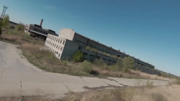 FPV-Drohne fliegt schnell und wendig zwischen verlassenen Industriegebäuden und in der Nähe von Baggern. — Stockvideo