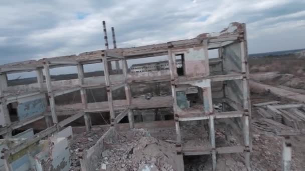 FPV κηφήνας πετά γρήγορα και ευέλικτο μεταξύ εγκαταλελειμμένων βιομηχανικών κτιρίων και γύρω από έναν εκσκαφέα. — Αρχείο Βίντεο