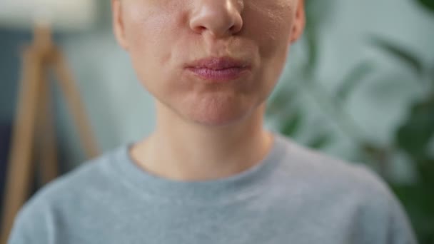 Mujer comiendo una rosquilla dulce en esmalte púrpura con salpicaduras. Primer plano — Vídeos de Stock