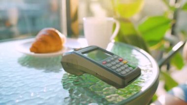 NFC kredi kartı ödemesi. Bir kafede NFC teknolojisiyle bağlantısız kredi kartıyla ödeme yapan bir kadın. Kablosuz para transferi. Kablosuz ödeme