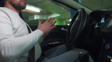 Otomatik otoparkta otopark için otomatik pilot kullanan bir adam yenilikçi bir şekilde araba kullanıyor.