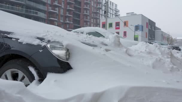 Carros cobertos de neve depois de uma nevasca de neve. Construção residencial em segundo plano. — Vídeo de Stock