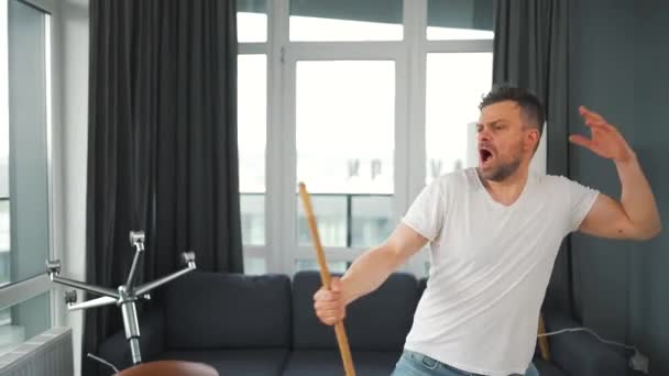 Człowiek sprzątanie domu i zabawy taniec i śpiew z miotłą — Wideo stockowe