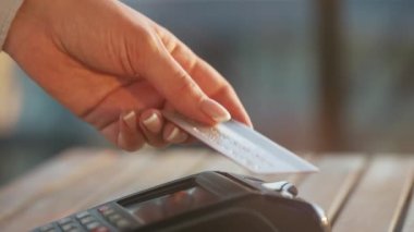 NFC kredi kartı ödemesi. NFC teknolojisiyle kredi kartıyla ödeme yapan bir kadın. Kablosuz para transferi. Kablosuz ödeme