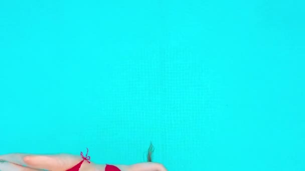 Vue du haut comme une femme en maillot de bain rouge couchée sur le dos dans la piscine. Concept relaxant — Video