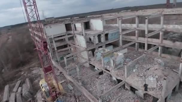 Drone FPV voa rapidamente e manobrável entre edifícios industriais abandonados e em torno de uma escavadeira. — Vídeo de Stock