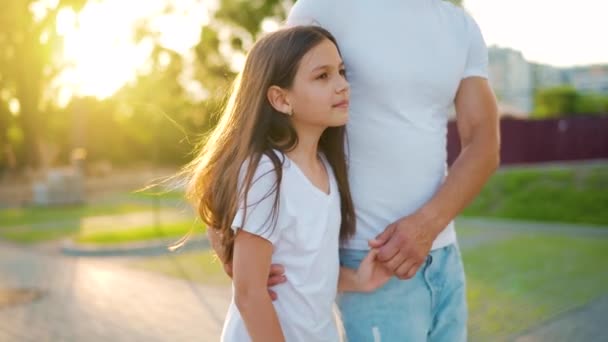 Papá y su hija caminan por su área al atardecer. Movimiento lento — Vídeos de Stock