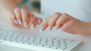 Bilgisayar klavyesinde yazı yazan kadın elleri. Uzak çalışma kavramı.