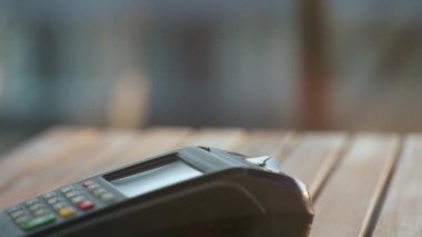 NFC kredi kartı ödemesi. NFC teknolojisiyle kredi kartıyla ödeme yapan bir kadın. Kablosuz para transferi. Kablosuz ödeme