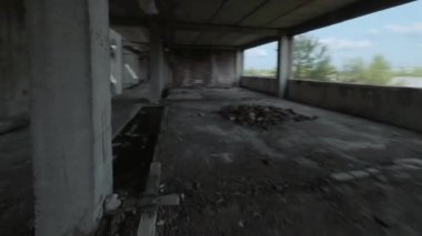FPV insansız hava aracı terk edilmiş bir binanın içinde hızla uçuyor. İnsanlar olmadan kıyamet sonrası konumu