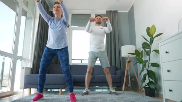 Kaukaskie para robi cardio ćwiczenia w domu w przytulny jasny pokój, zwolniony ruch. — Wideo stockowe