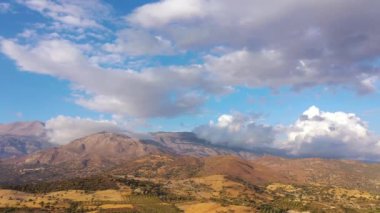 Yunanistan 'daki Girit adasının havadan görünüşü. Dağ manzarası, zeytin ağaçları, gün batımında bulutlu gökyüzü..