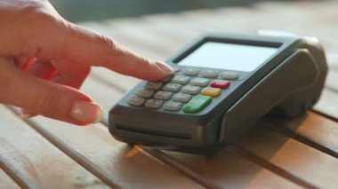 NFC kredi kartı ödemesi. NFC teknolojisiyle kredi kartıyla ödeme yapan bir kadın. Kablosuz para transferi. Kablosuz ödeme