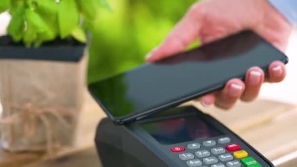 Pago sin contacto con smartphone. Concepto de pago inalámbrico. Close-up, mujer que utiliza la tecnología NFC billetera sin efectivo smartphone para pagar la orden en la terminal bancaria. — Vídeo de stock