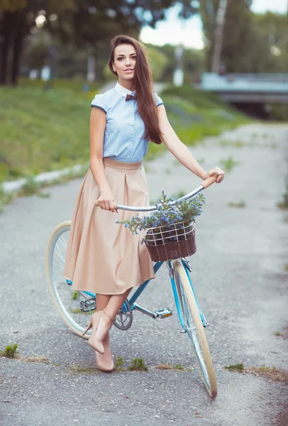 Молодая элегантно одетая женщина с велосипедом, летом и образом жизни — стоковое фото