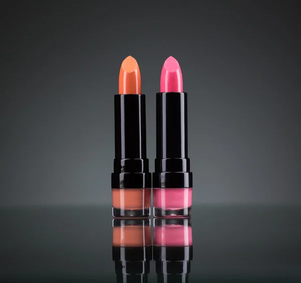 Two bright lipsticks on a black — Stock Photo, Image