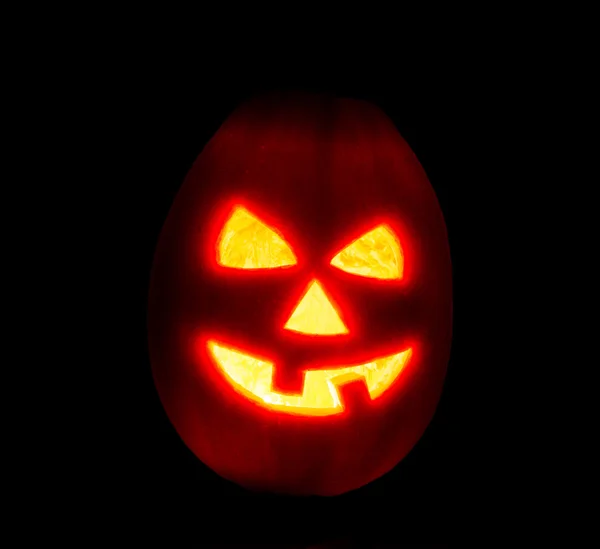 Vela de abóbora de Halloween jack-o-lanterna acesa, isolada em preto — Fotografia de Stock