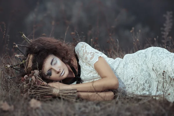 Девушка по образу невесты, лежащей на земле — стоковое фото