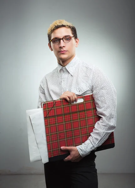 Junger ernster Mann mit Brille und Zeichenmappe in der Hand — Stockfoto