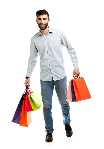 Bonito homem segurando sacos de compras — Fotografia de Stock