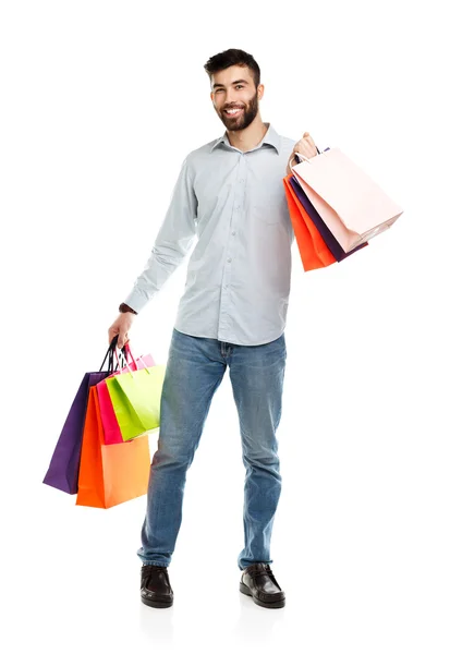 Bonito homem segurando sacos de compras — Fotografia de Stock