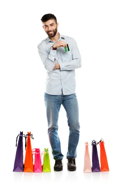 Handsome smiling man with shopping bags and holding credit card — Stock Photo, Image