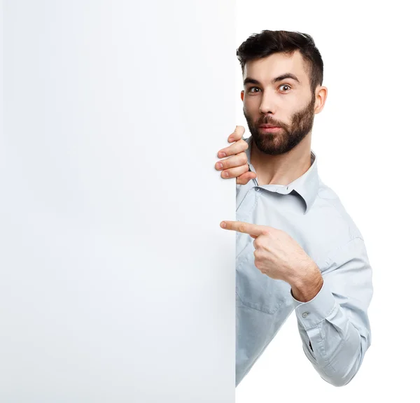 Egy fiatal szakállas ember mutatja üres jelzőtábla, elszigetelt, felett fehér — Stock Fotó
