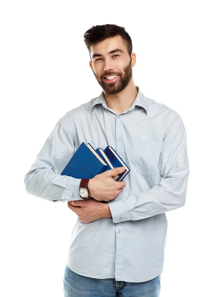 Junger bärtiger lächelnder Mann mit Büchern in der Hand auf weißem Grund — Stockfoto