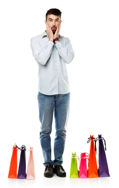 Handsome man with shopping bags is shocked — Stock Photo, Image