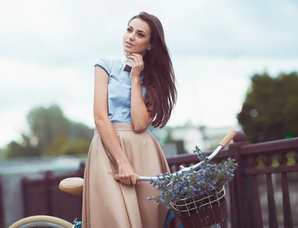 Jovem mulher bonita, elegantemente vestida com bicicleta — Fotografia de Stock