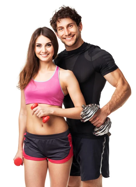 Athletic couple - man and woman with dumbbells on the white — Stock Photo, Image