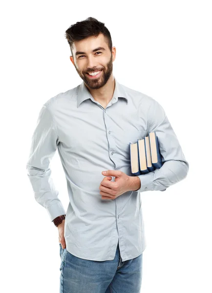 Junger bärtiger lächelnder Mann mit Büchern in der Hand auf weißem Grund — Stockfoto